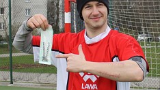 Grocho z żelastwem wyjętym z ręki, na przedramieniu widoczne blizny, na koszulce białe szwy